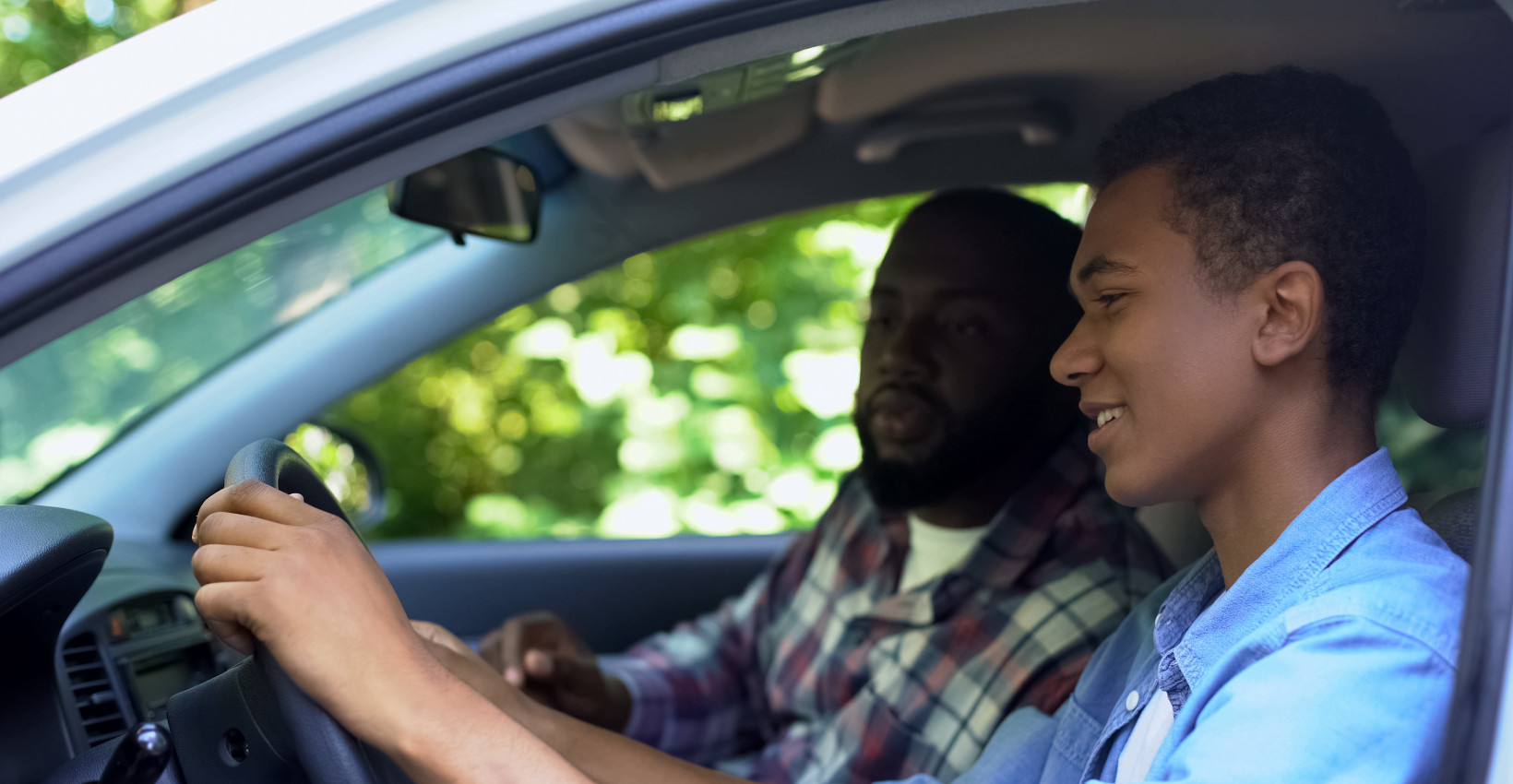 Parent and child driving a car.