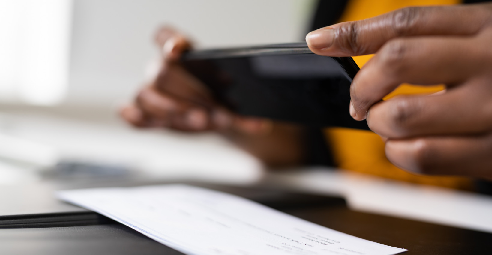 Person taking a photo of their check with their phone.