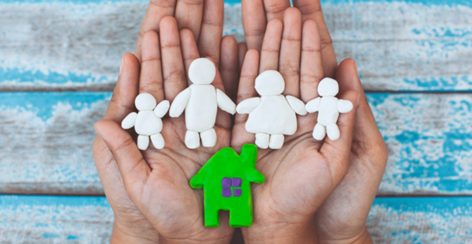 Paper cutout family in a pair of hands