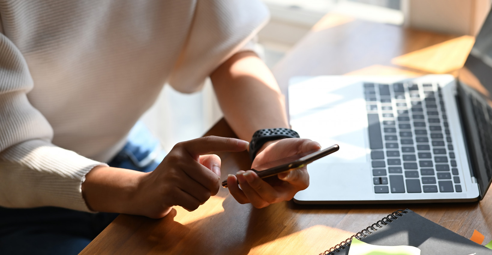 Person using a phone and a computer to enroll in e-statements