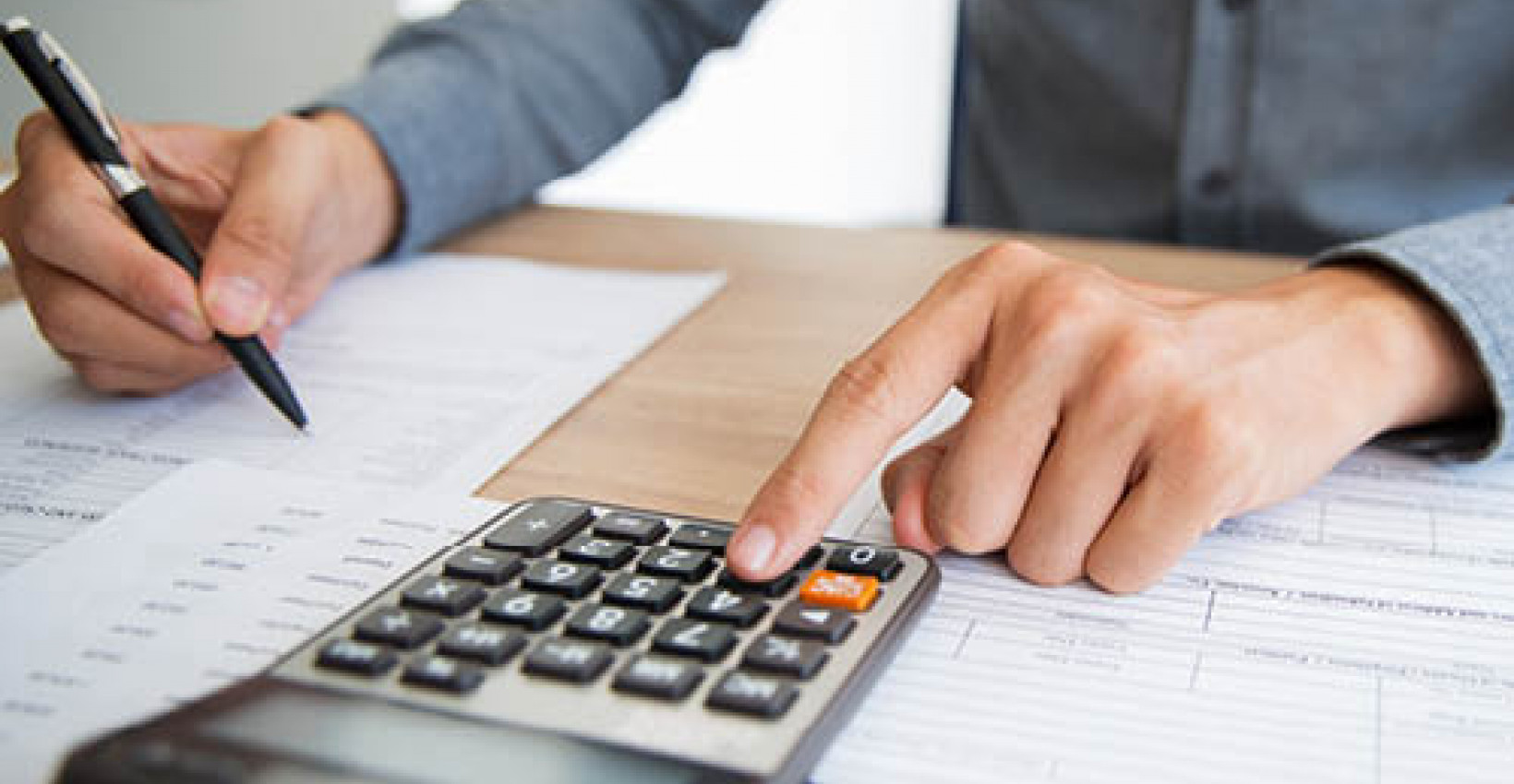 A closeup of a woman pressing a button a calculator