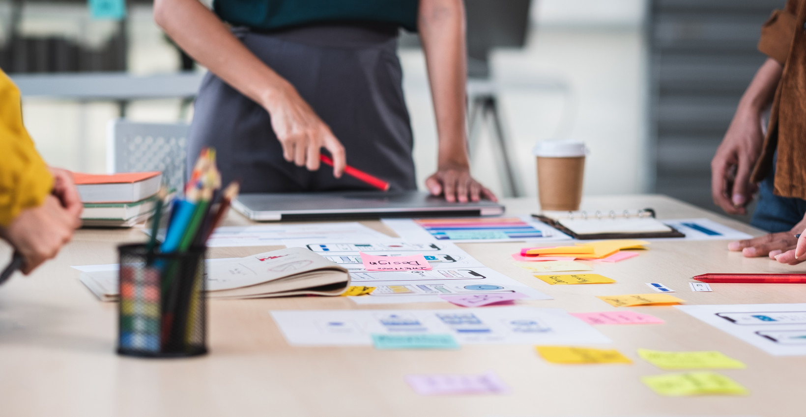 People standing around a table with business plans on them