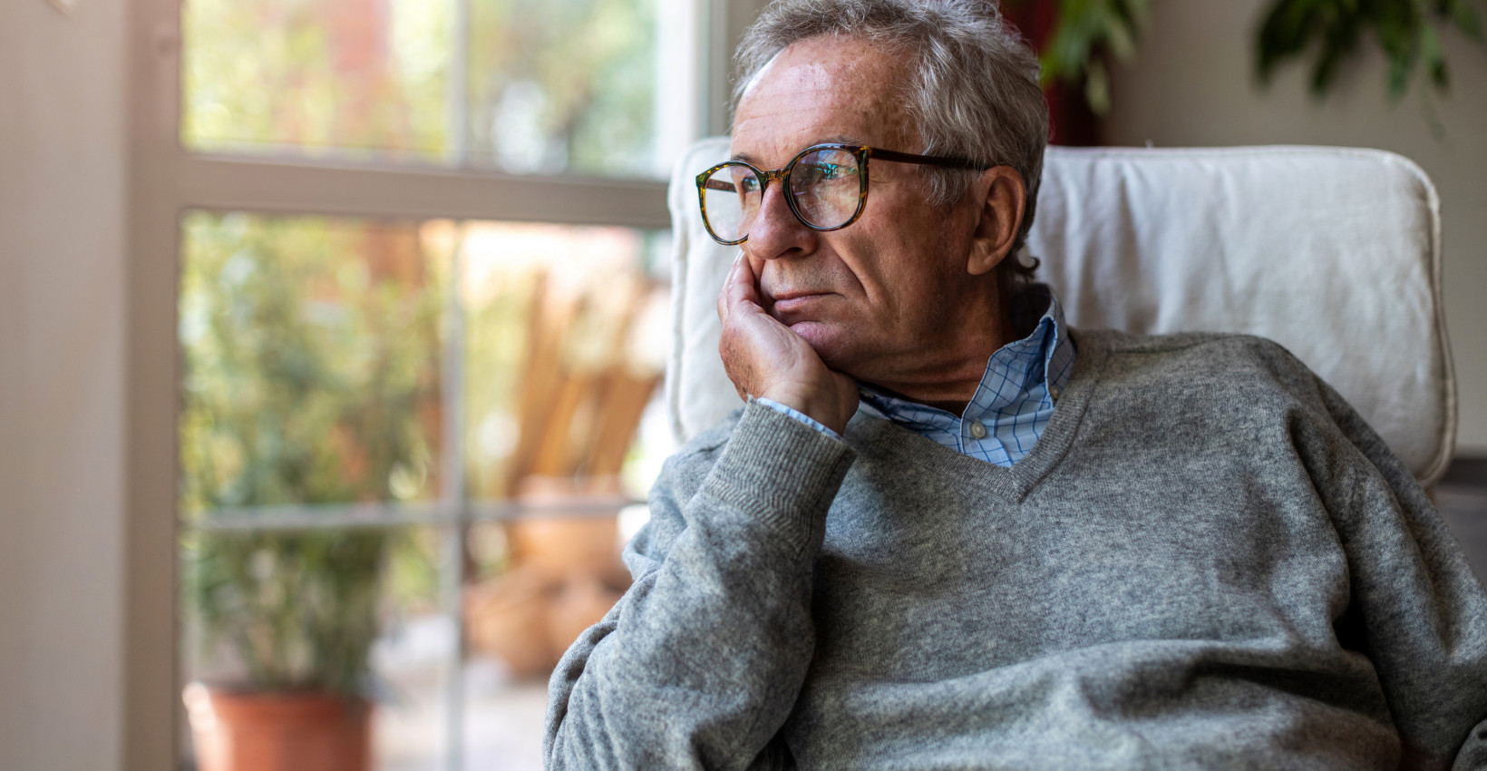 somber man looks out window