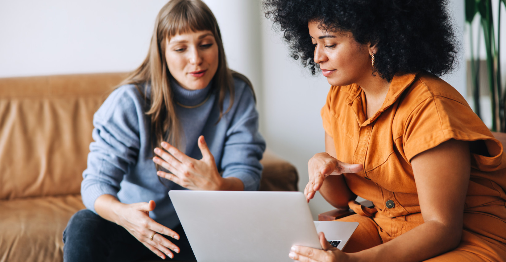 two women look at a computer