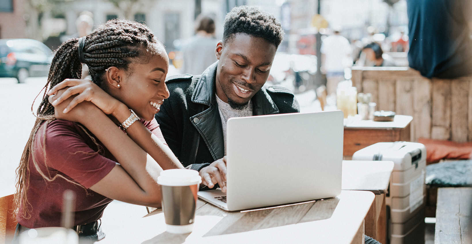 a couple sits at a laptop