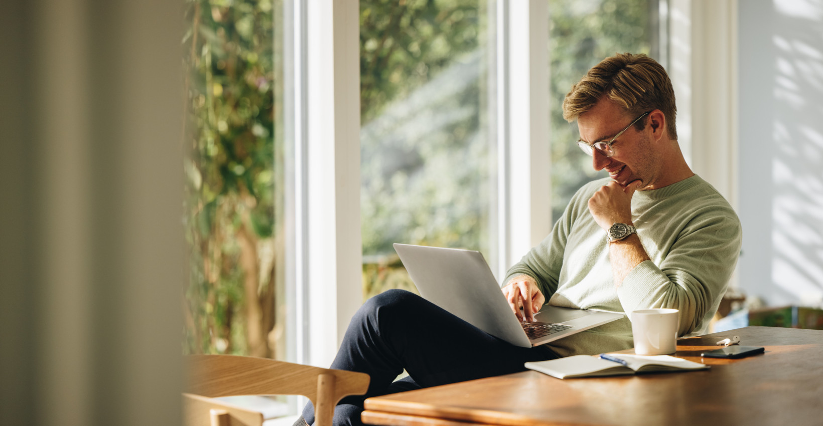 a man sits with a laptop 