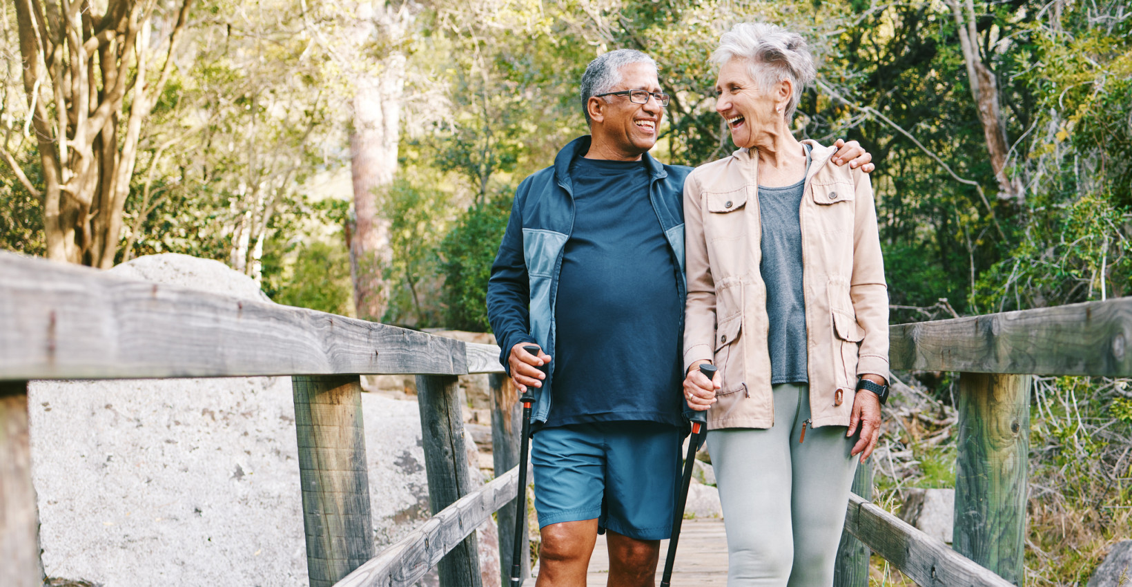 an older couple happily walks together on a bridge