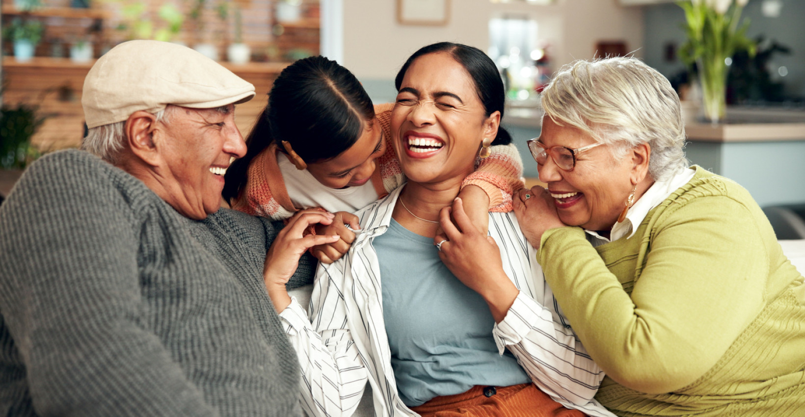 a family sits on a couch laughing