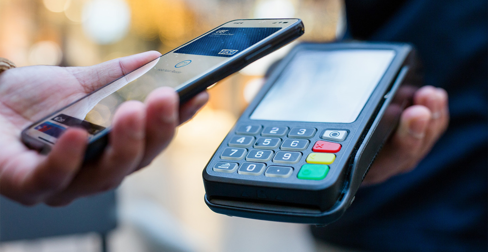 a person holds a phone near a payment machine