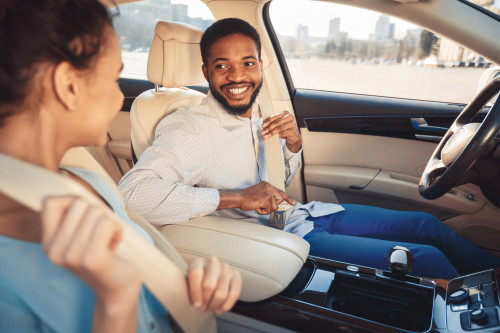 People buckling up inside a car.