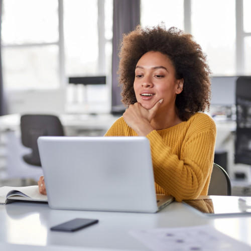 Woman smiling at her computer.