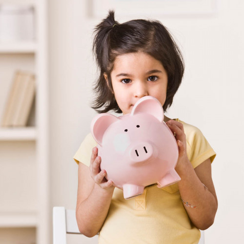 Young girl holding a piggy bank