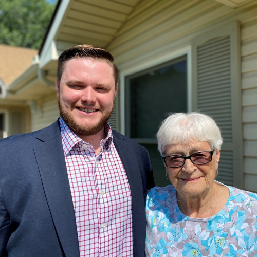 A handsome young man posing with an elderly woman