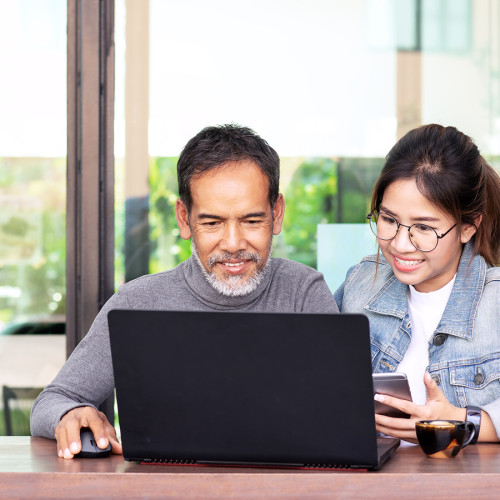 A husband and wife looking at a laptop