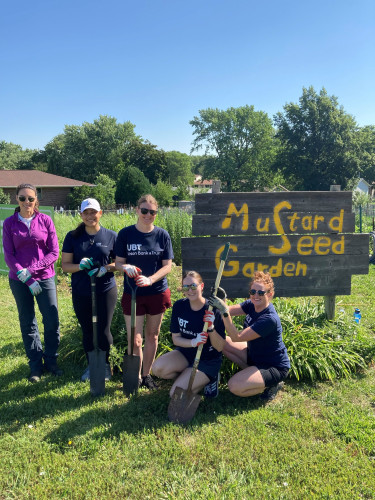 Several UBT employees volunteering at a community garden