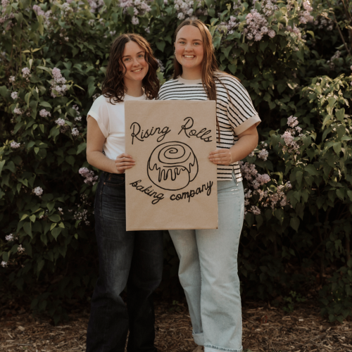 alexa and riley carter hold a sign that says rising rolls baking company