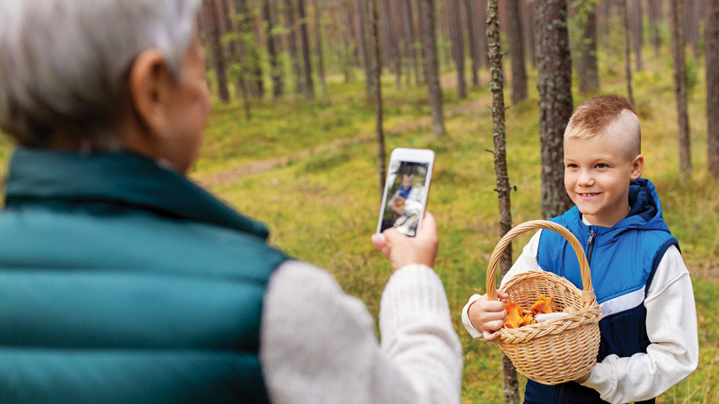 a grandfather takes a photo of his grandson