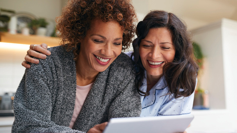 two women look at a computer