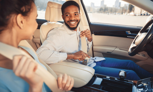 People buckling up inside a car.