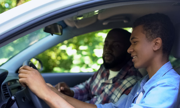 Parent and child driving a car.