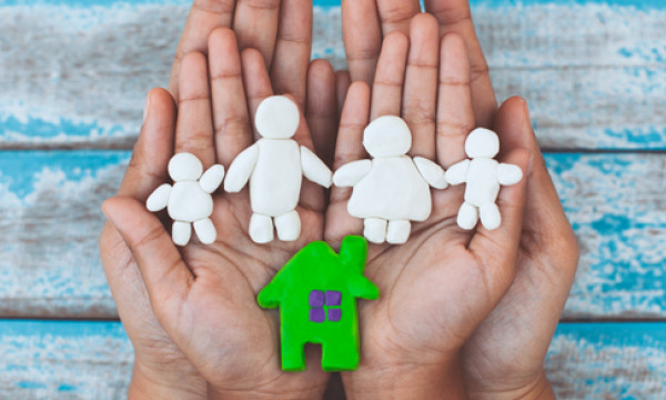 Paper cutout family in a pair of hands