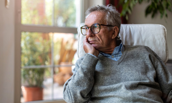 somber man looks out window