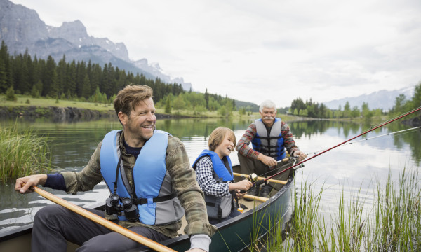 grandfather with his son and grandson in a canoe in water