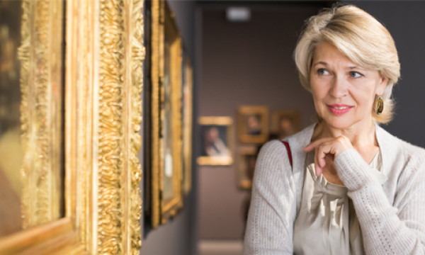 a woman views art that is likely expensive