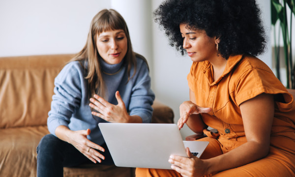 two women look at a computer