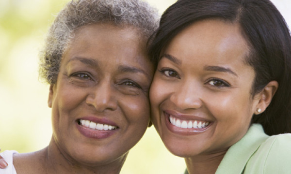 a mother and daughter stand cheek to cheek
