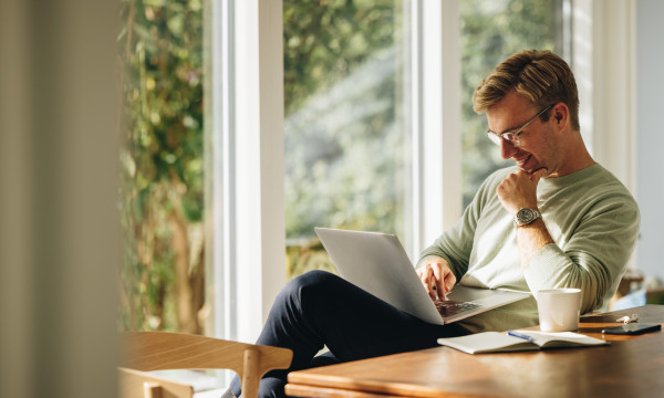 a man sits with a laptop 