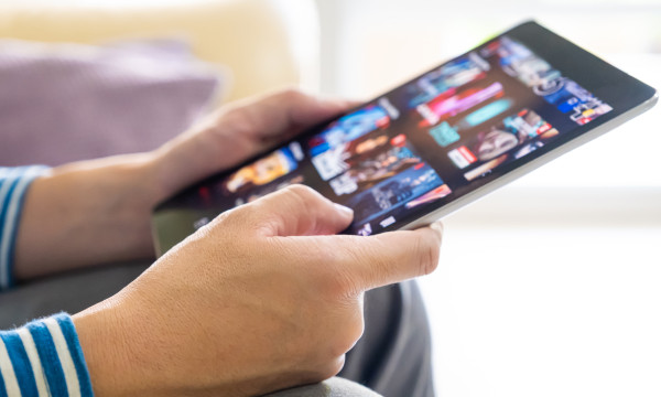 a person holds a tablet with apps pulled up