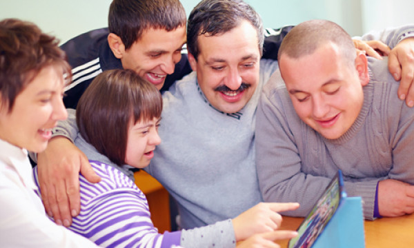 a group of people gather around a tablet