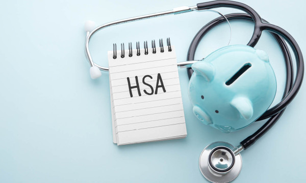 a blue piggy bank sits on a table with a stethoscope and notepad