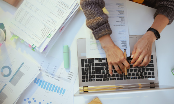 A pair of hands typing on a laptop