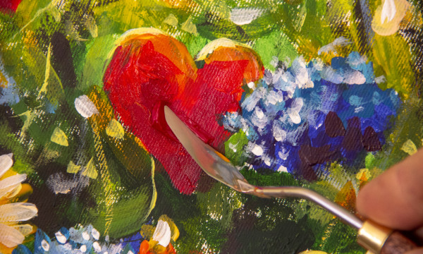 a piece of art that features a red heart and blue flowers with a pallet knife
