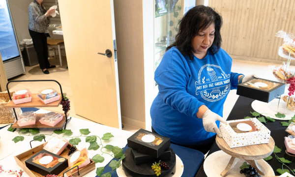 fay the owner of my big fat greek bakery stands at her table at union bank place pop-up shop