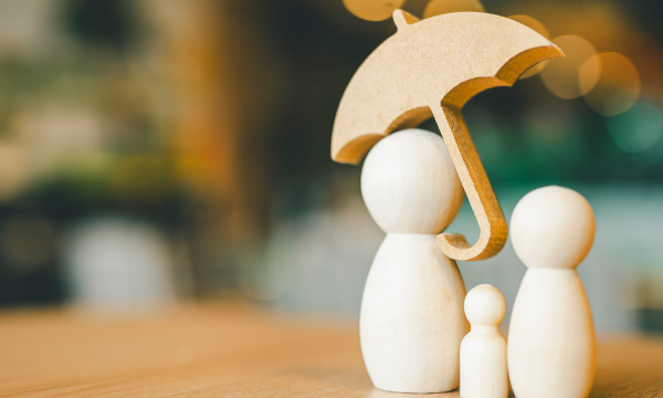 2 big and 1small wooden figure stand under a wooden umbrella