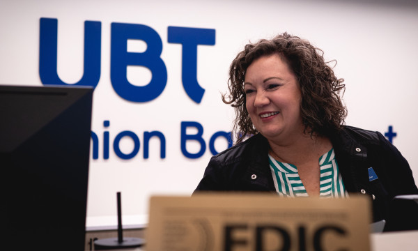Elizabeth stands behind the teller pod at union bank place smiling