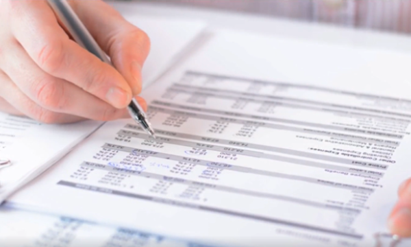 Someone using a pen to make edits to a budget
