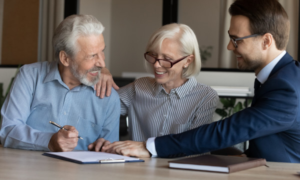 an older couple sit with a younger man filling out paperwork