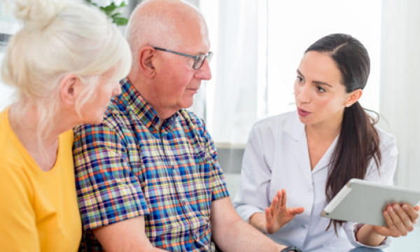 an older couple sits with a middle aged woman in conversation