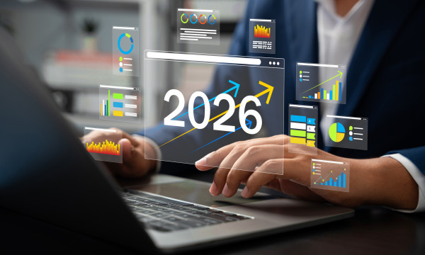 two people sit at a desk with a graphic overtop that says 2026